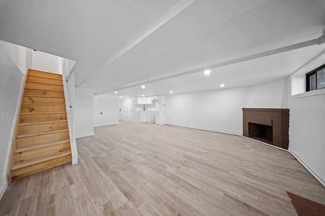 22518 Mentone Ave, Laurelton, NY 11413 - finished basement with a brick fireplace, stairs, light wood-type flooring, and recessed lighting