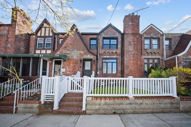 22518 Mentone Ave, Laurelton, NY 11413 - view of front of house with a chimney, brick siding, a sunroom, and a fenced front yard
