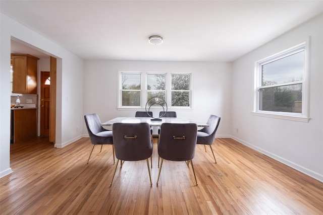 dining room with baseboards and light wood-type flooring