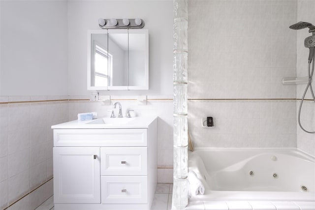 bathroom featuring tile walls, a combined bath / shower with jetted tub, wainscoting, and vanity