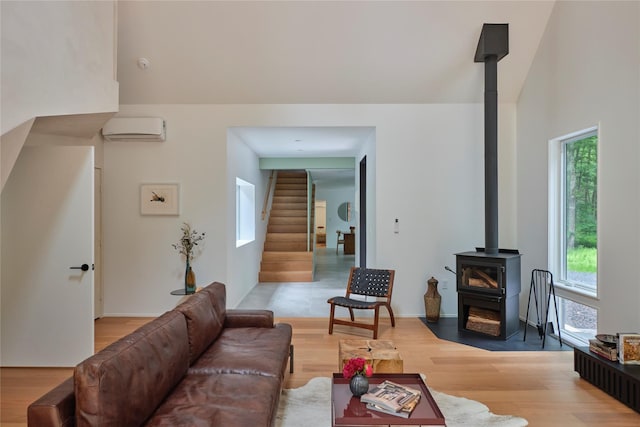 64 Hoyt Rd, Glen Spey, NY 12737 - living room with a wood stove, stairway, a wall mounted air conditioner, and light wood-style flooring