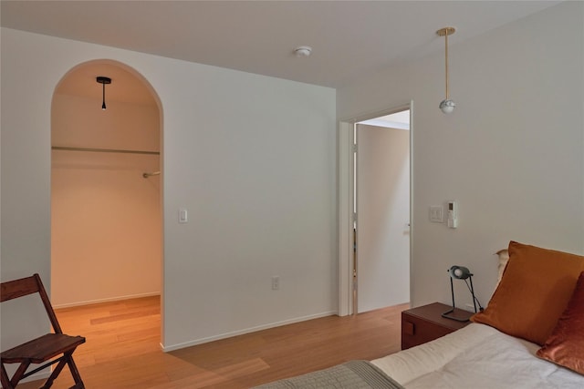 64 Hoyt Rd, Glen Spey, NY 12737 - bedroom featuring light wood-style flooring, arched walkways, and a walk in closet