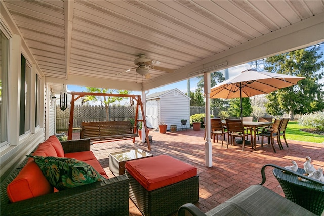 view of patio / terrace featuring an outbuilding, a fenced backyard, outdoor lounge area, a shed, and outdoor dining space