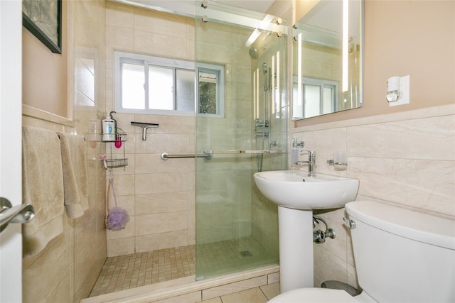 full bathroom featuring tile walls, a stall shower, and toilet