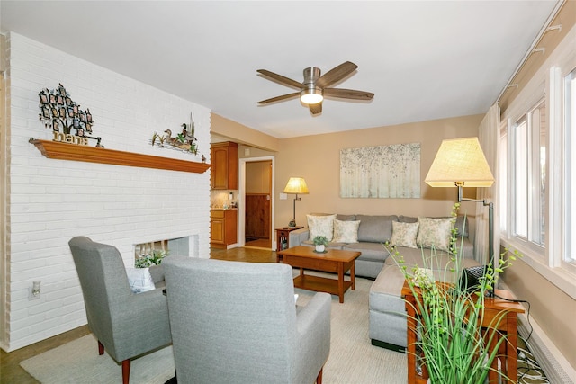 living area with baseboards, a ceiling fan, and a brick fireplace