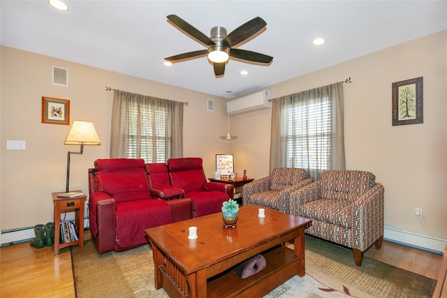 living area featuring a baseboard radiator, visible vents, light wood-type flooring, and a wall mounted air conditioner