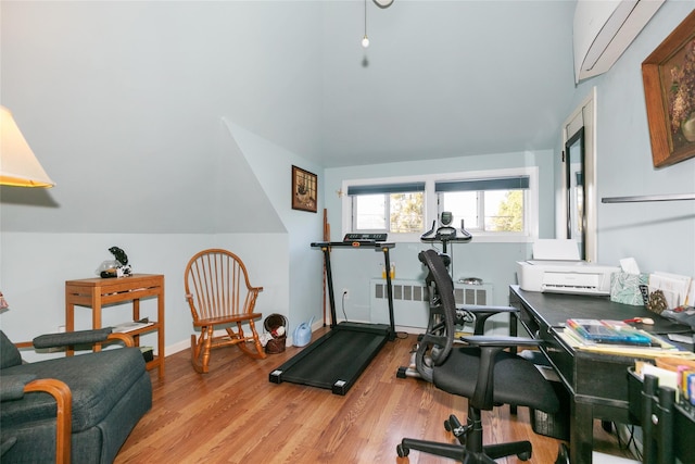 workout area with radiator heating unit, wood finished floors, vaulted ceiling, and baseboards