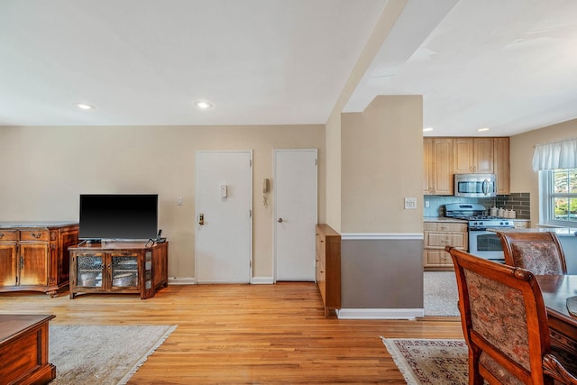 living area featuring baseboards, recessed lighting, and light wood-style flooring