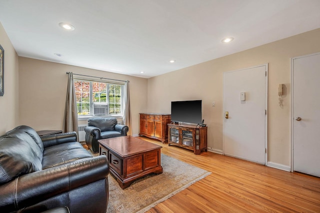 living room with light wood-style floors, recessed lighting, and baseboards