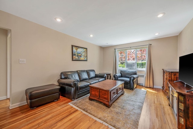 living area with recessed lighting, baseboards, radiator heating unit, and light wood-type flooring