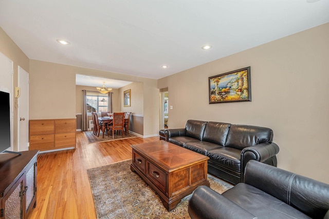 living area with an inviting chandelier, recessed lighting, light wood finished floors, and baseboards