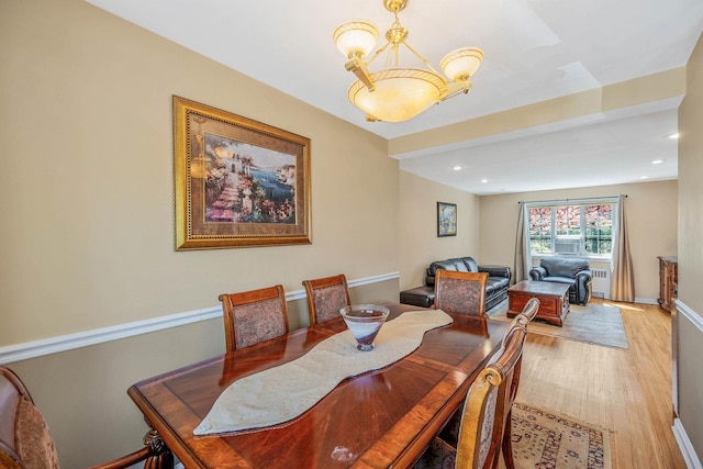 dining space featuring recessed lighting, a notable chandelier, wood finished floors, and radiator