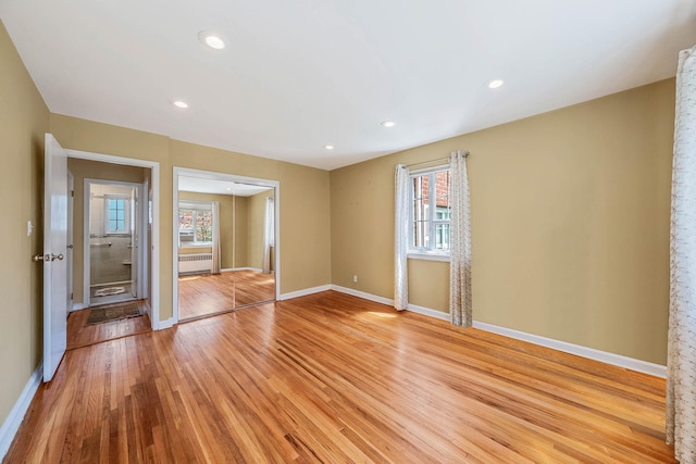 spare room featuring light wood-style floors, baseboards, plenty of natural light, and recessed lighting