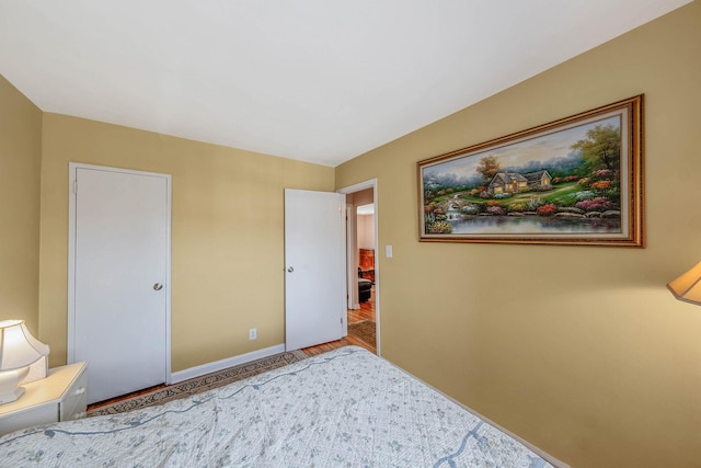 bedroom featuring baseboards and wood finished floors
