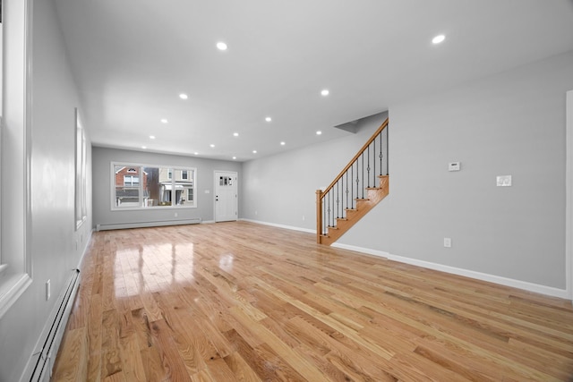 unfurnished living room with baseboard heating, stairs, light wood finished floors, and recessed lighting