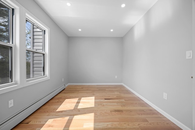 unfurnished room featuring a baseboard radiator, recessed lighting, baseboards, and light wood-type flooring