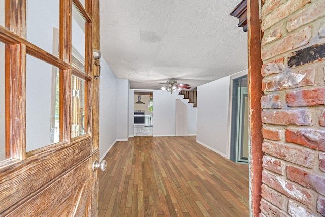 57 River Ave, Cornwall On Hudson, NY 12520 - unfurnished living room featuring a textured ceiling, hardwood / wood-style flooring, stairway, ceiling fan, and baseboards