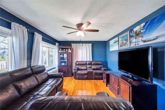 living room with a ceiling fan and light wood finished floors