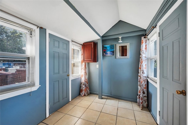 entryway featuring light tile patterned floors and lofted ceiling