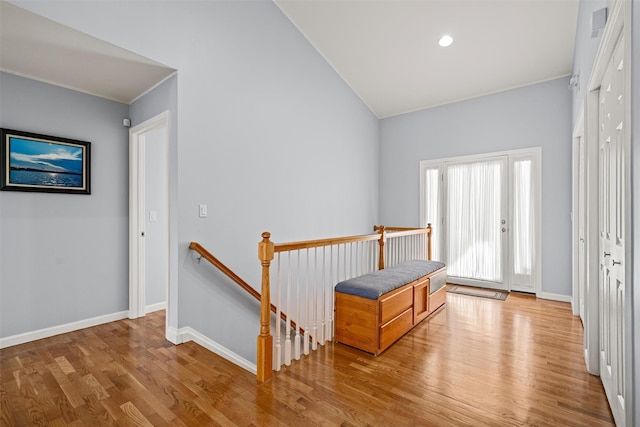hall featuring visible vents, baseboards, an upstairs landing, light wood-style floors, and recessed lighting