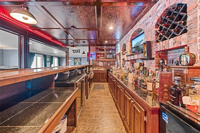 bar featuring light wood finished floors and a community bar