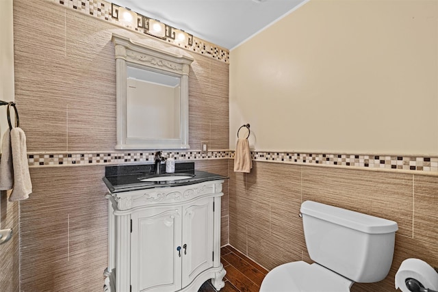 bathroom with crown molding, toilet, tile walls, and vanity