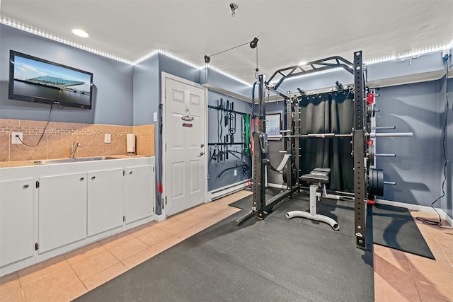 workout area with recessed lighting, light tile patterned floors, a sink, and a baseboard radiator