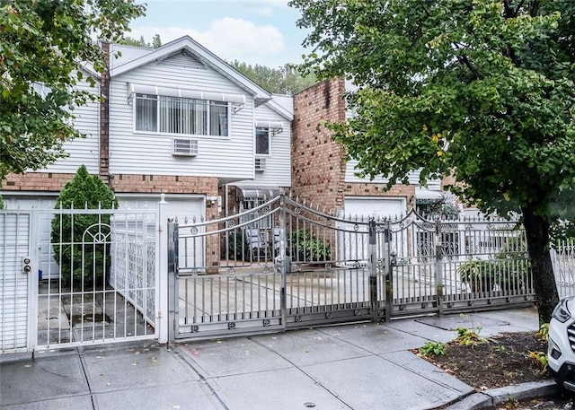 exterior space with a gate, fence, concrete driveway, and a garage