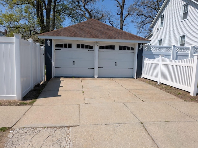 detached garage featuring fence