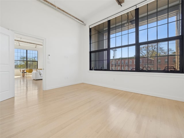 spare room featuring baseboards and wood finished floors