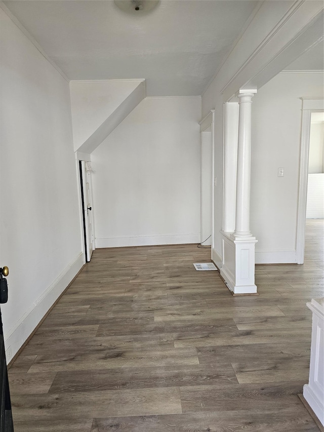 interior space with baseboards, decorative columns, and wood finished floors
