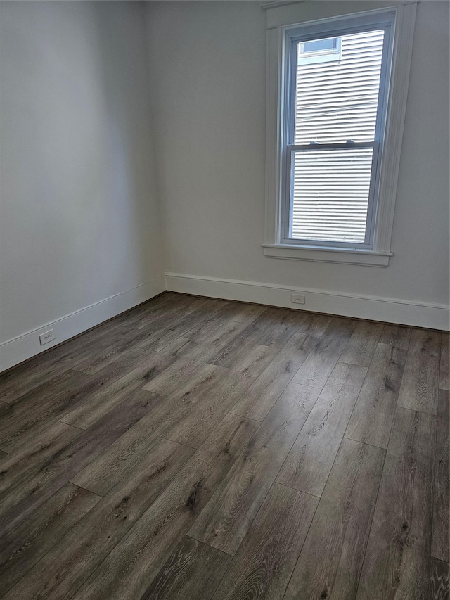 spare room with dark wood finished floors and baseboards