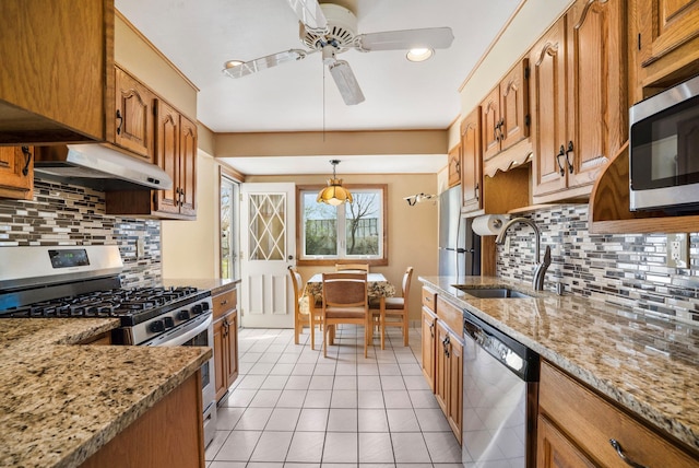 kitchen with a sink, under cabinet range hood, light tile patterned floors, ceiling fan, and appliances with stainless steel finishes