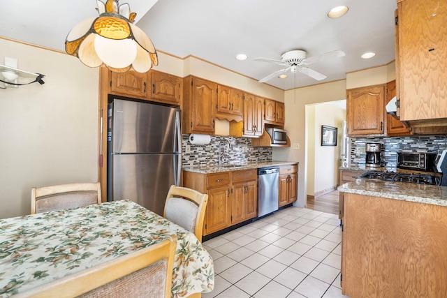 kitchen with tasteful backsplash, ceiling fan, appliances with stainless steel finishes, and a sink