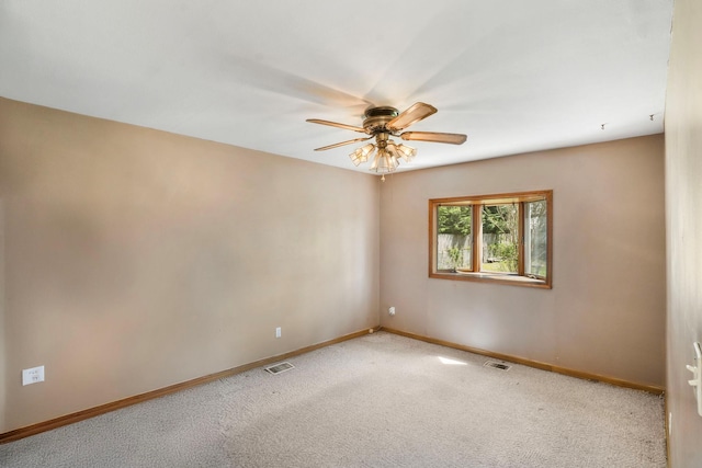 empty room featuring baseboards, visible vents, light carpet, and ceiling fan