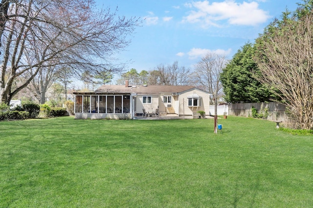 back of house featuring a sunroom, a patio, a lawn, and fence