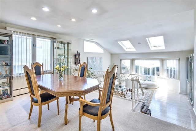 dining room with recessed lighting, a baseboard heating unit, and lofted ceiling with skylight