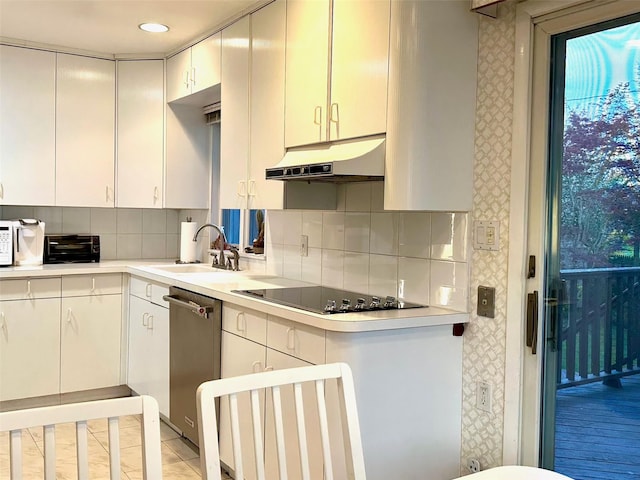 kitchen featuring a sink, under cabinet range hood, black electric stovetop, light countertops, and stainless steel dishwasher
