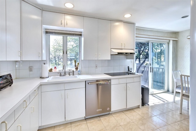 kitchen featuring a sink, under cabinet range hood, black electric stovetop, light countertops, and stainless steel dishwasher