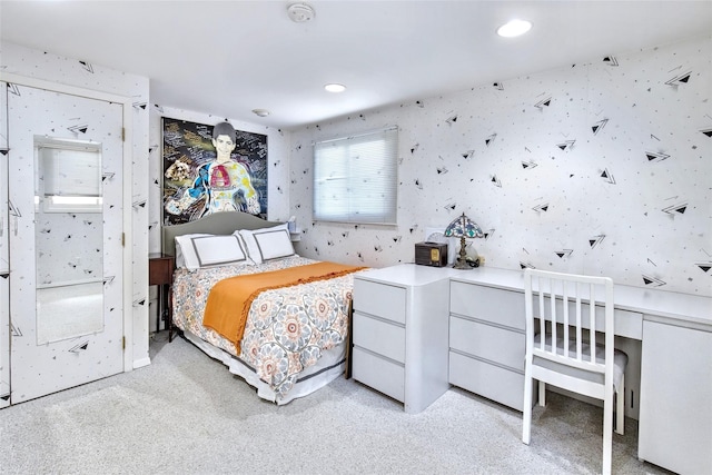 bedroom with wallpapered walls and light colored carpet