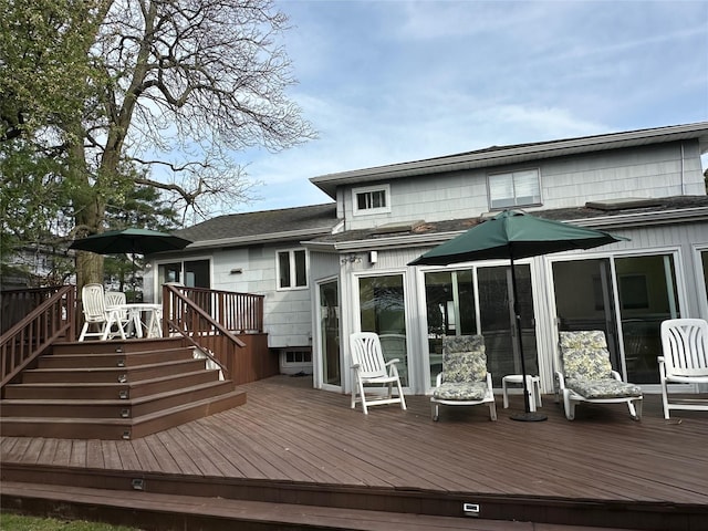 back of property featuring a deck and a shingled roof