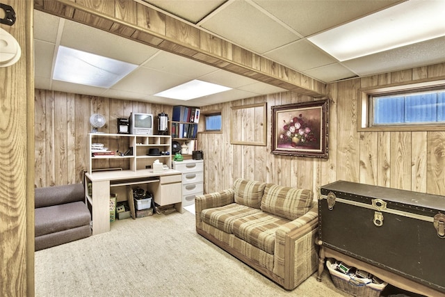 interior space featuring wooden walls, carpet flooring, and a drop ceiling