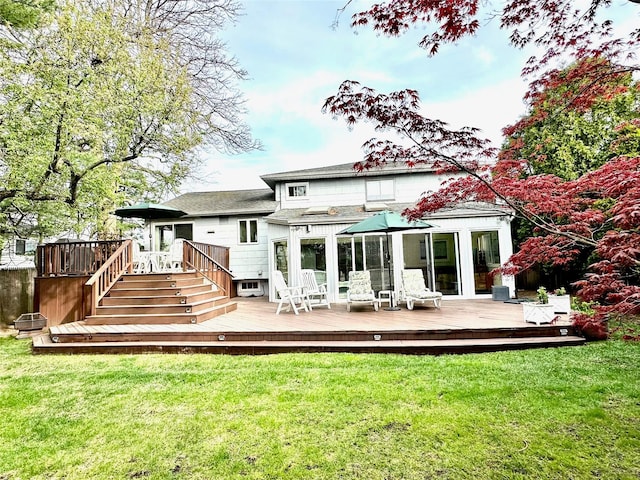 back of house featuring a deck and a lawn