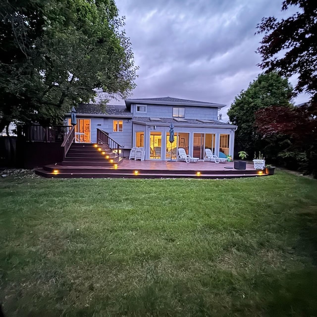 rear view of house with a wooden deck and a yard