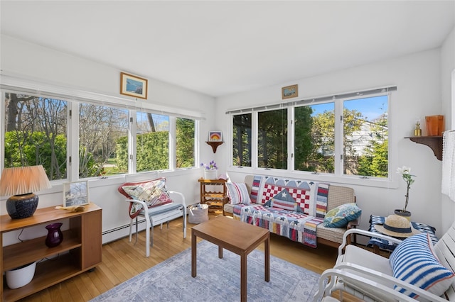 sunroom / solarium with a deck, a wealth of natural light, wood finished floors, and a baseboard heating unit