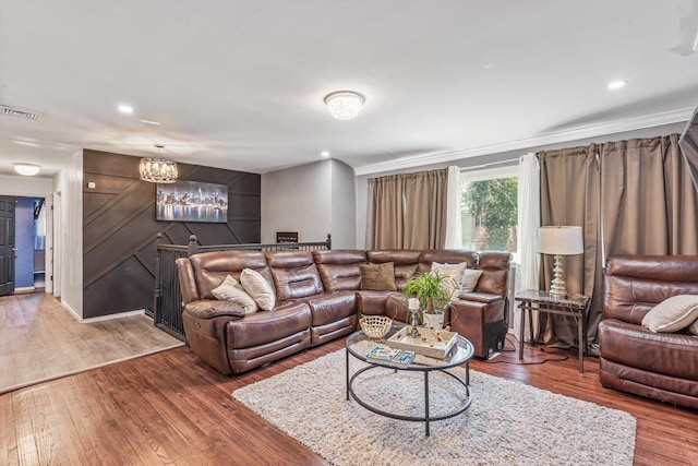 living room with a chandelier, visible vents, recessed lighting, ornamental molding, and wood finished floors