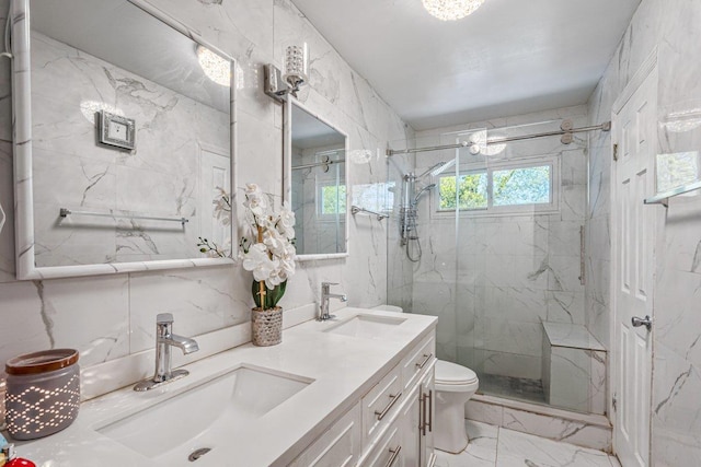 full bath featuring a marble finish shower, marble finish floor, toilet, and a sink