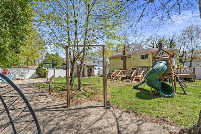 view of playground featuring an outbuilding, a yard, and fence