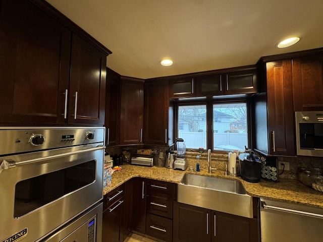 kitchen with appliances with stainless steel finishes, backsplash, recessed lighting, and a sink