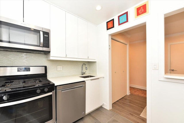 36 Barstow Unit 2-B, Great Neck, NY 11021 - kitchen with tasteful backsplash, a sink, light countertops, white cabinets, and stainless steel appliances